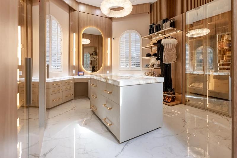 Custom walk-in closet · Central island, glass-front wardrobes, and an illuminated mirror