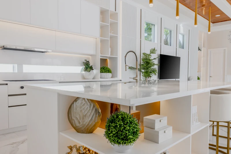 Sunlit custom kitchen with white cabinetry and brass details