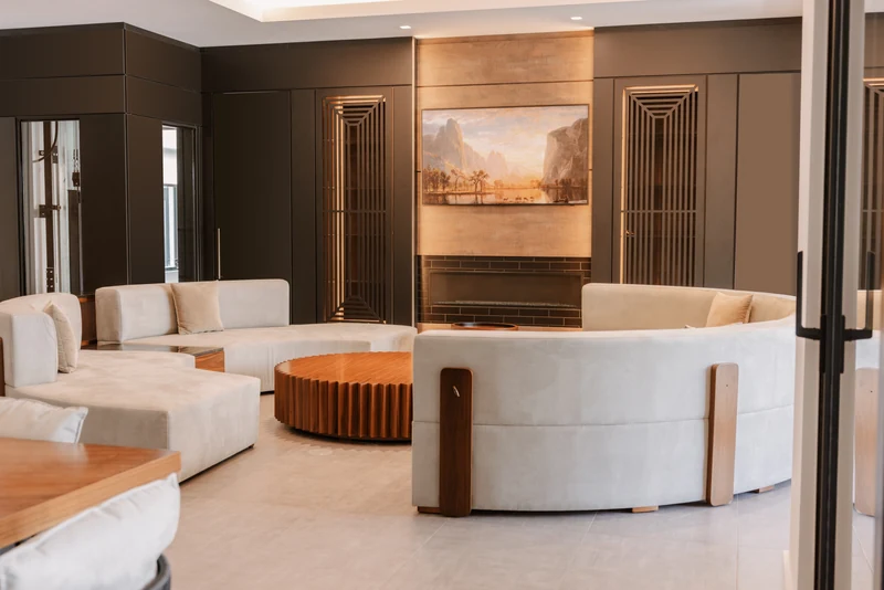 Living room with a broad seating arrangement, a fireplace, and full-height cabinetry.